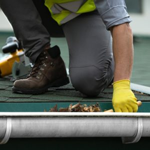 trabajador-limpiando-canalon-obstruido-suciedad